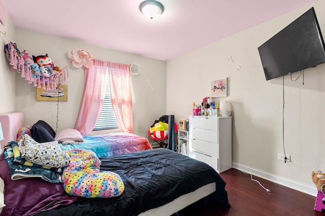 bedroom with baseboards and wood finished floors