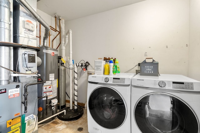 laundry area with laundry area, washer and clothes dryer, gas water heater, and heating unit