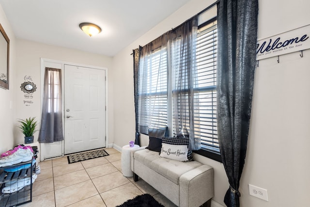 foyer featuring baseboards and light tile patterned flooring