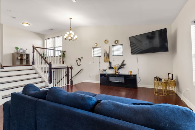 living room with stairway, baseboards, a chandelier, and wood finished floors