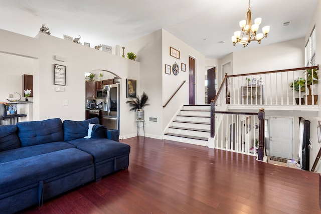 living room featuring stairway, wood finished floors, visible vents, and an inviting chandelier