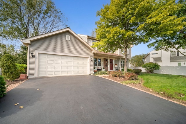 view of front of house with a porch, a garage, and a front yard