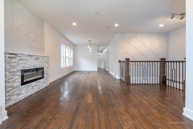 unfurnished living room featuring a fireplace and dark wood-type flooring