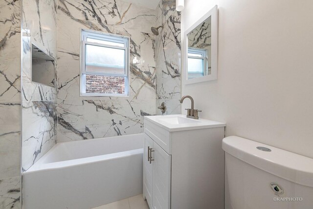 full bathroom with vanity, tiled shower / bath, and toilet