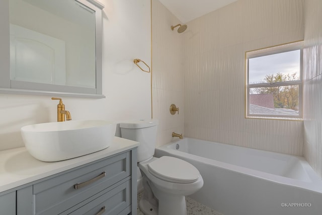 full bathroom featuring tiled shower / bath combo, vanity, and toilet