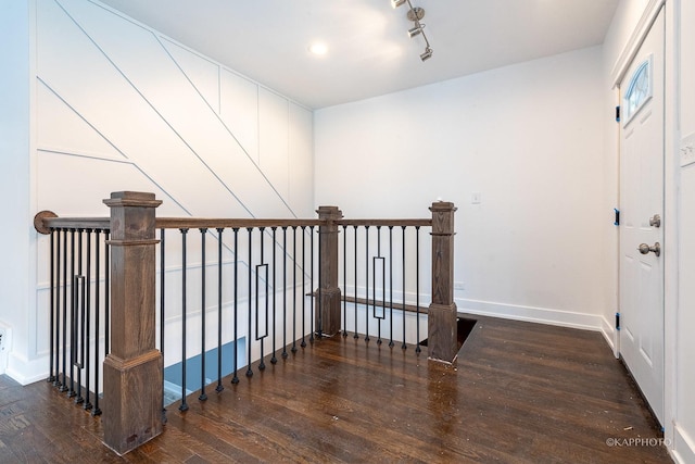 hallway featuring dark wood-type flooring and track lighting