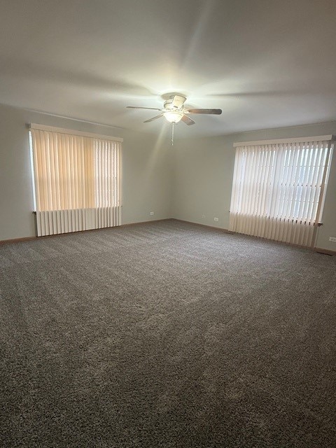 carpeted empty room featuring ceiling fan