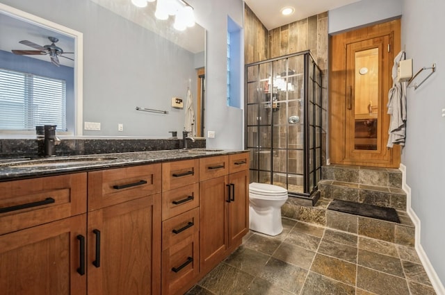 bathroom featuring walk in shower, ceiling fan, vanity, and toilet