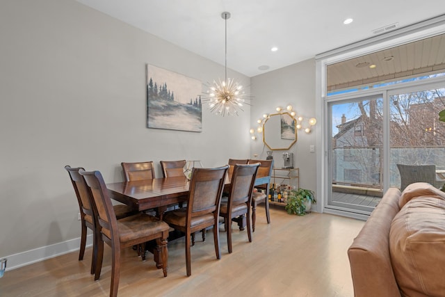 dining space with a chandelier and light wood-type flooring