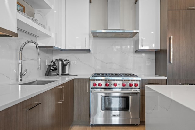 kitchen with white cabinetry, premium stove, and wall chimney range hood