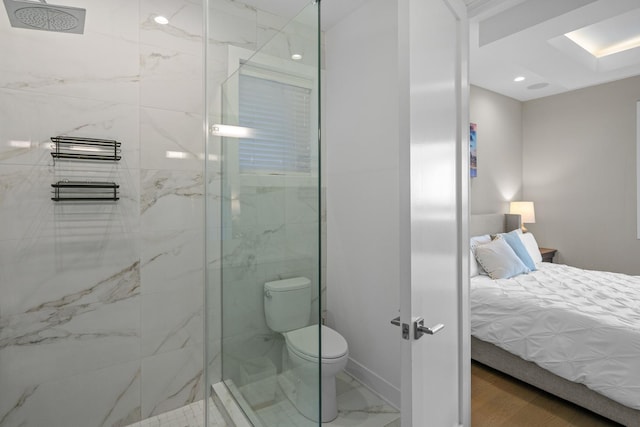 bathroom featuring a tile shower and toilet