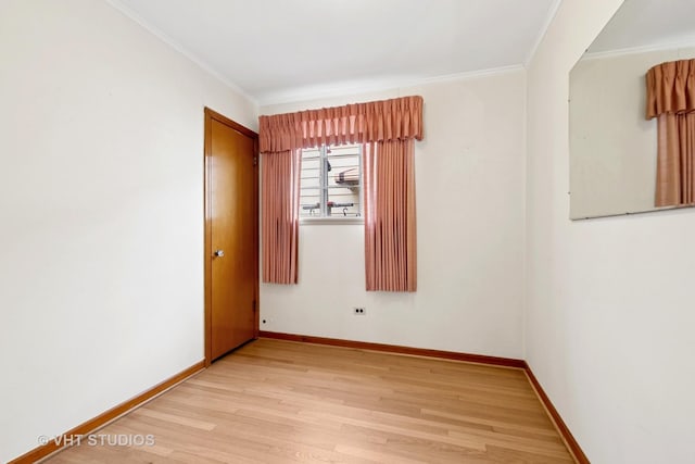 empty room featuring baseboards, wood finished floors, and crown molding