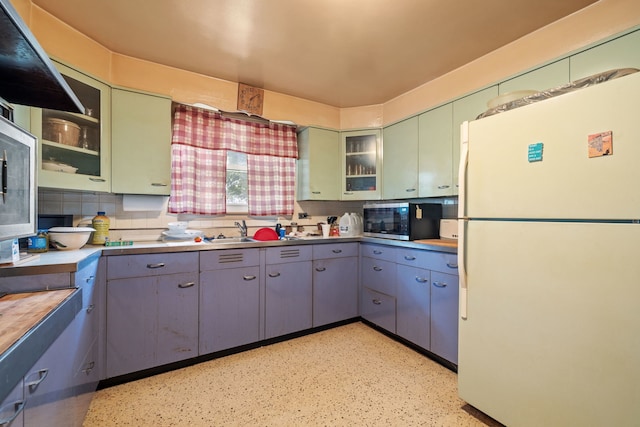 kitchen with tasteful backsplash, sink, and white refrigerator