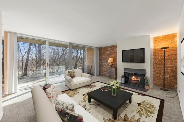 carpeted living area featuring a lit fireplace, brick wall, and a healthy amount of sunlight