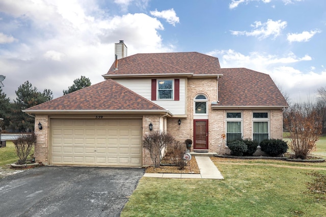 traditional home featuring aphalt driveway, brick siding, a chimney, a garage, and a front lawn