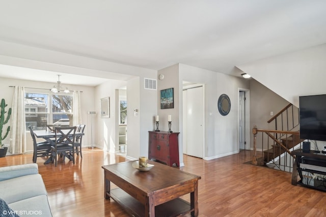 living room with light wood-type flooring and an inviting chandelier