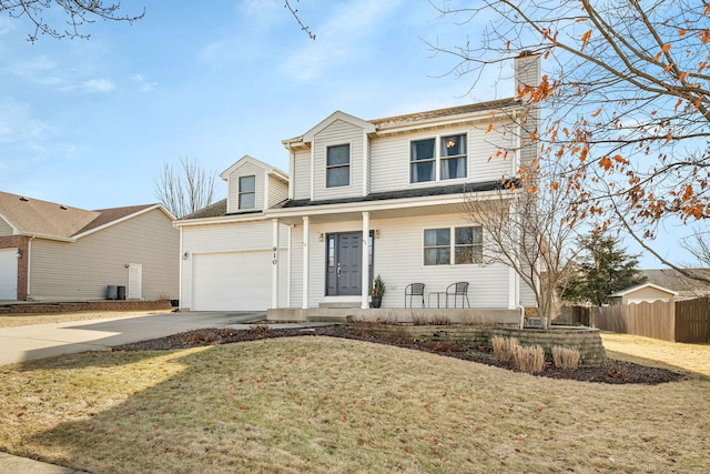 view of front of property with a garage, a front yard, and covered porch