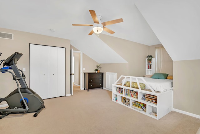 carpeted bedroom featuring ceiling fan, vaulted ceiling, and a closet