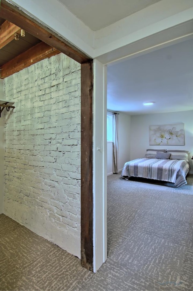 carpeted bedroom featuring brick wall
