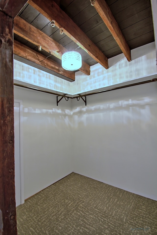 spacious closet with beamed ceiling and carpet flooring