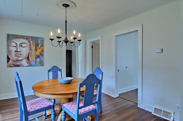 dining room with a chandelier, ornamental molding, baseboards, visible vents, and dark wood-style floors
