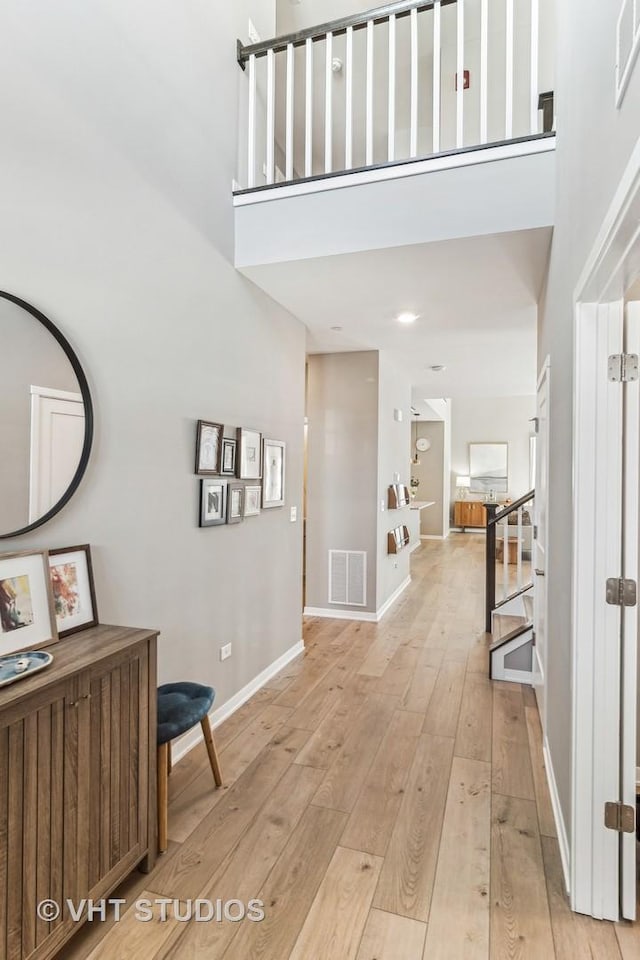 foyer entrance featuring light wood-type flooring and a high ceiling