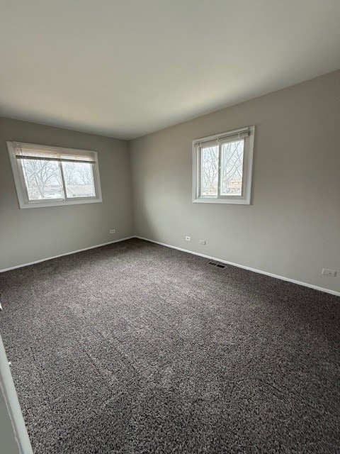 carpeted spare room featuring plenty of natural light