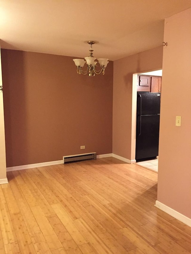 unfurnished room with a baseboard radiator, a chandelier, and light hardwood / wood-style floors