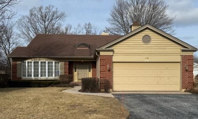 ranch-style home with a garage and a front lawn