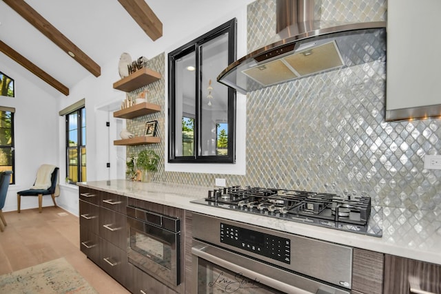 kitchen featuring wall chimney range hood, appliances with stainless steel finishes, backsplash, and lofted ceiling with beams