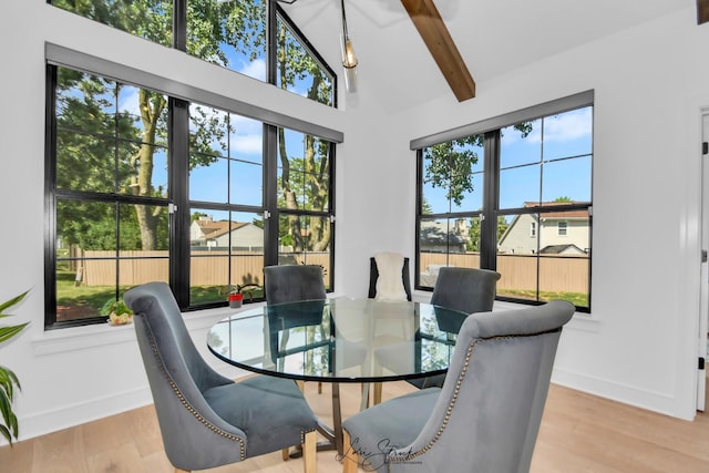 dining room with light hardwood / wood-style flooring, high vaulted ceiling, plenty of natural light, and beamed ceiling