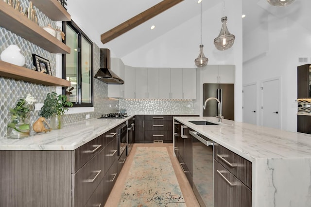 kitchen with sink, wall chimney range hood, stainless steel appliances, beam ceiling, and decorative backsplash