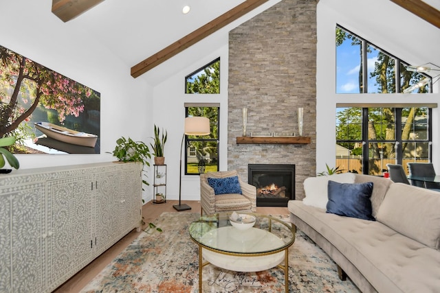 living room with high vaulted ceiling, beamed ceiling, hardwood / wood-style floors, and a stone fireplace