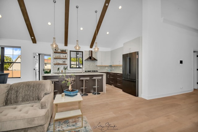 kitchen with a kitchen breakfast bar, dark brown cabinetry, decorative light fixtures, a kitchen island, and high end refrigerator