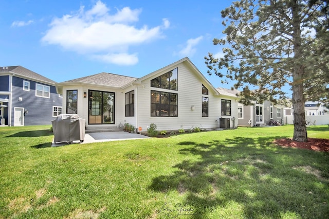 rear view of property featuring a patio, a yard, and cooling unit