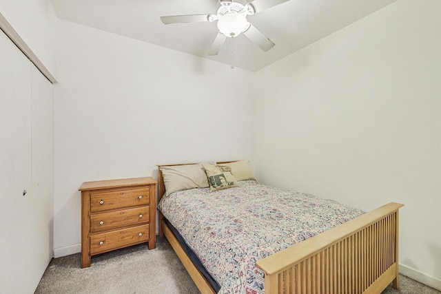 carpeted bedroom with ceiling fan and a closet