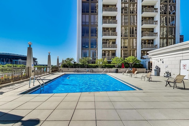 community pool with fence and a patio