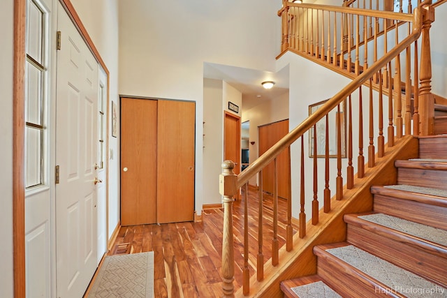 entryway with a towering ceiling and light wood-type flooring