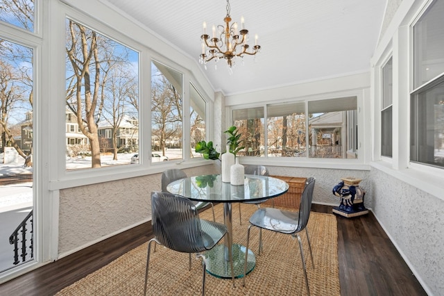 sunroom / solarium featuring an inviting chandelier