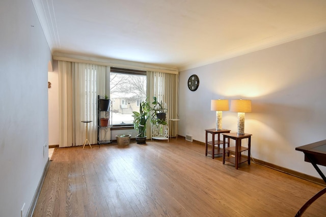 living area with crown molding and wood-type flooring