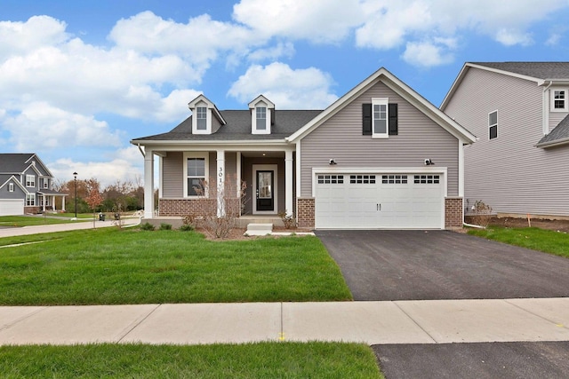 view of front of home with a garage, covered porch, and a front yard