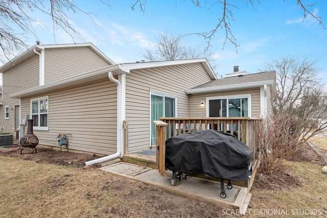 back of property featuring a wooden deck and a yard