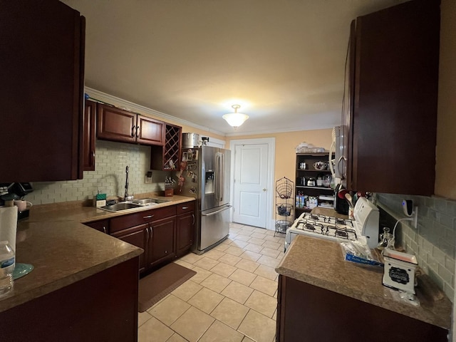 kitchen with sink, stainless steel fridge, tasteful backsplash, ornamental molding, and white gas stove