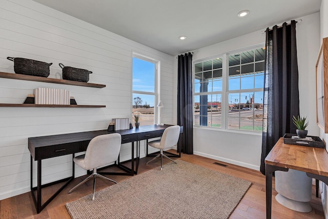 office area with built in desk, plenty of natural light, and hardwood / wood-style floors