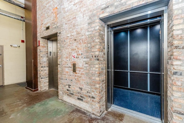 interior space with concrete flooring and elevator