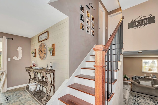 staircase featuring wooden walls