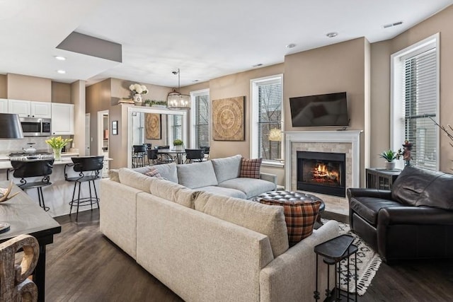 living room featuring recessed lighting, a fireplace, dark wood finished floors, and visible vents