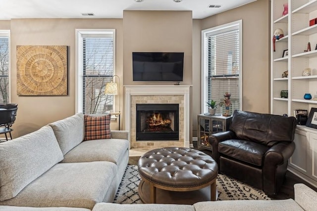 living area with a tile fireplace and visible vents