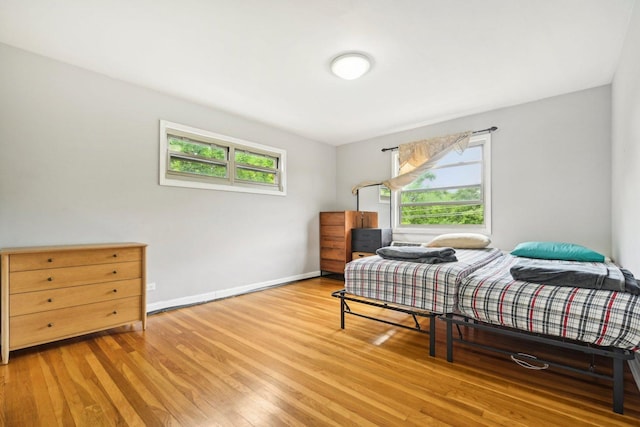 bedroom featuring multiple windows and light hardwood / wood-style floors