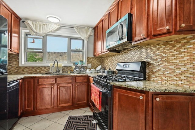 kitchen featuring light tile patterned flooring, sink, tasteful backsplash, light stone countertops, and black appliances